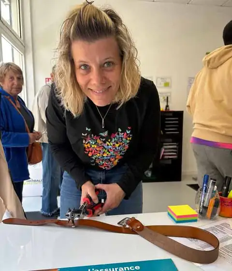 Une membre du club perce un nouveau trou à sa ceinture